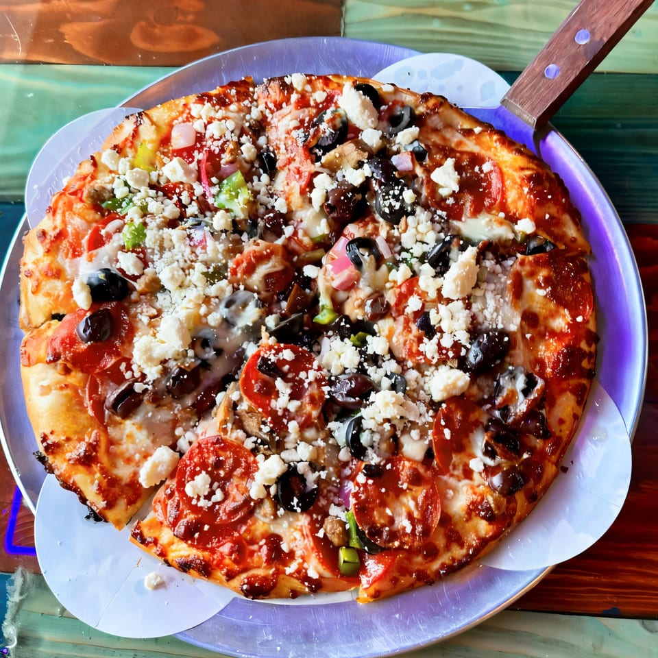A Task Force Pizza with pepperoni, olives, green peppers, and feta cheese on a metal pan.