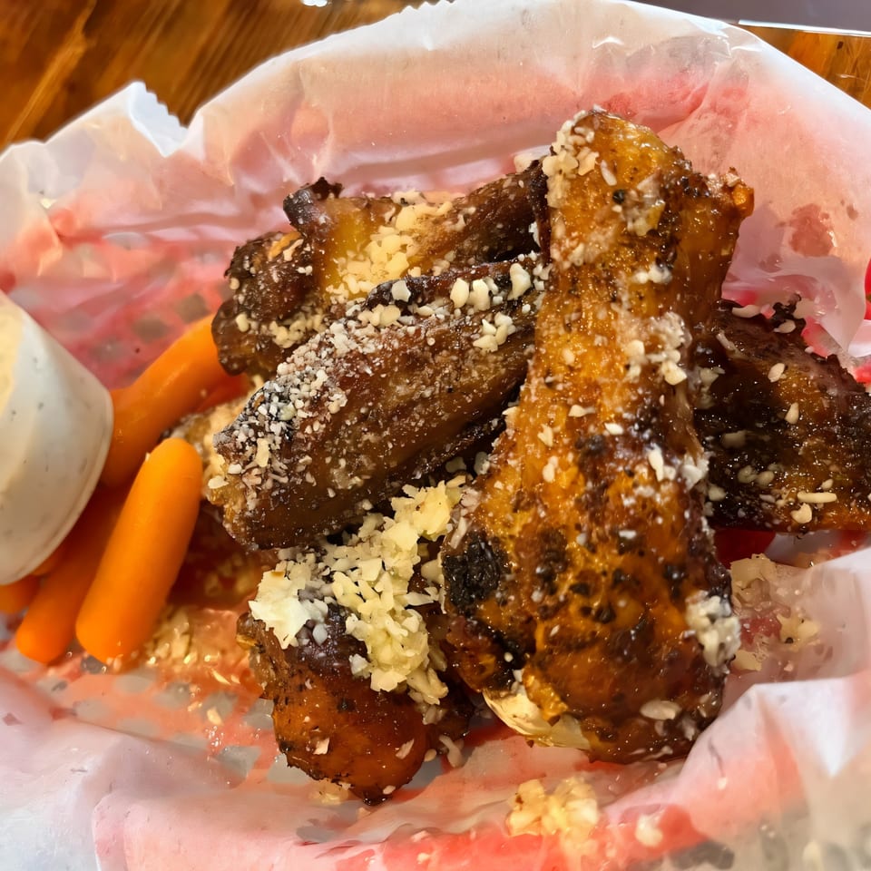 Task Force Pizza's garlic parmesan wings with baby carrots and ranch dressing in a red basket.