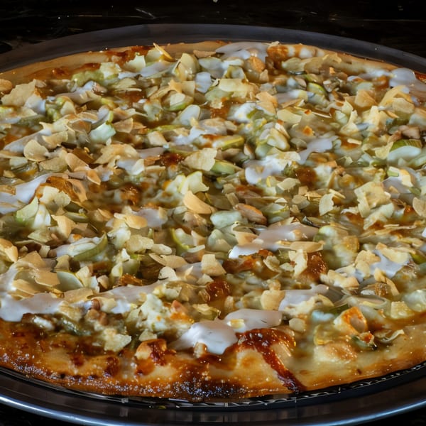 Close-up of a Task Force Pizza with white sauce, green toppings, and toasted almond flakes.